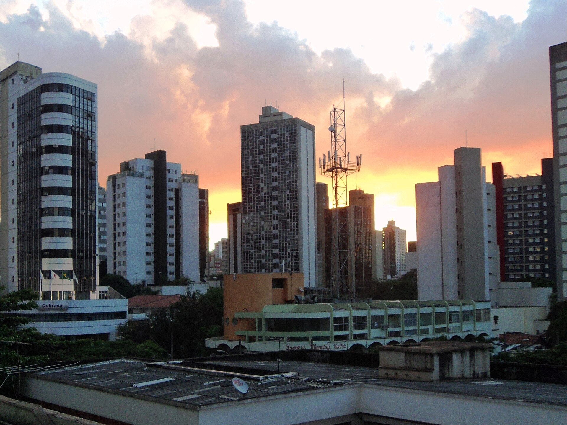 Pôr do sol entre os prédios da Savassi, em Belo Horizonte, com o céu alaranjado atrás das torres